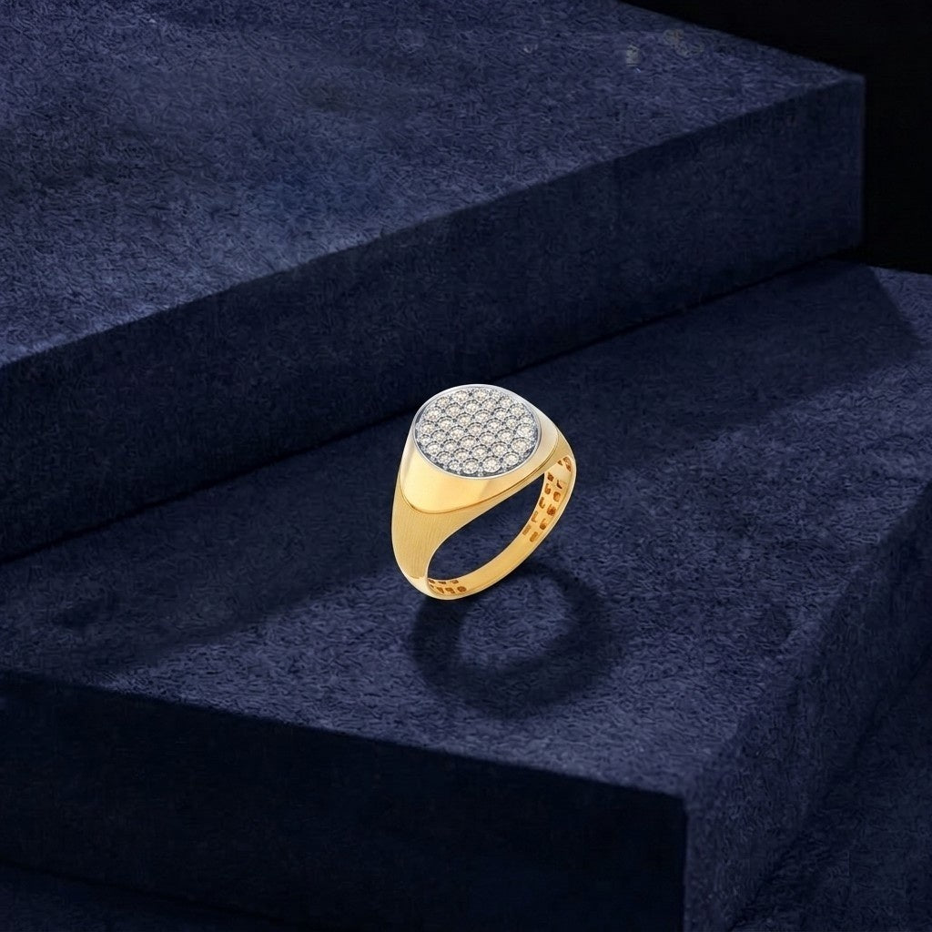Gold ring with a diamond-studded center on a dark blue surface.