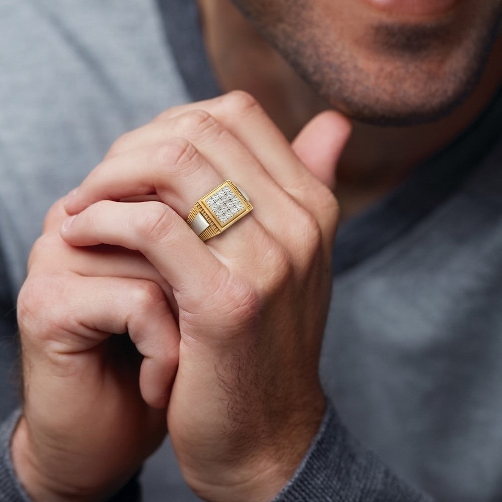 Close-up of a hand wearing a gold ring with a diamond, against a blurred background.