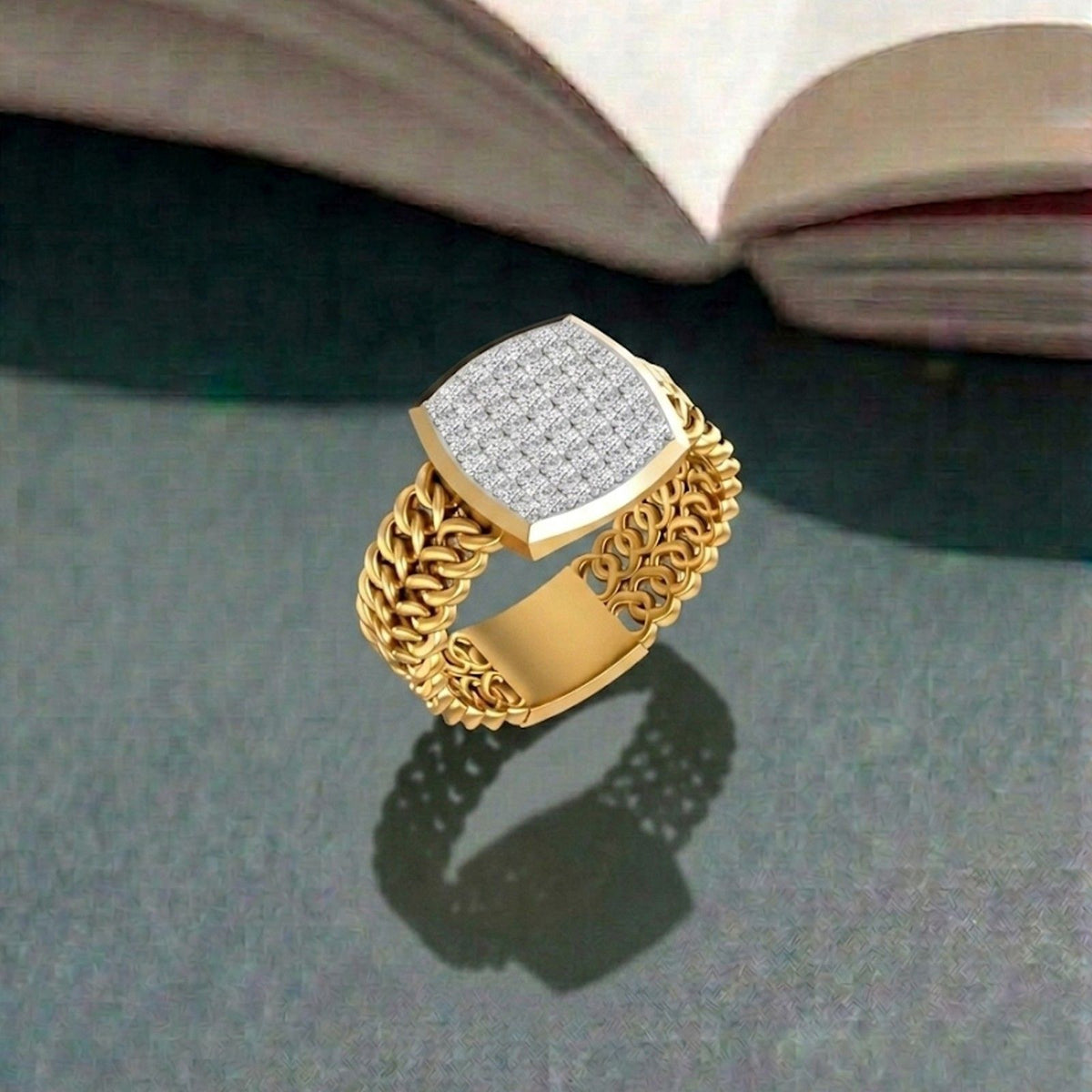 Gold ring with diamond-studded top on a gray surface