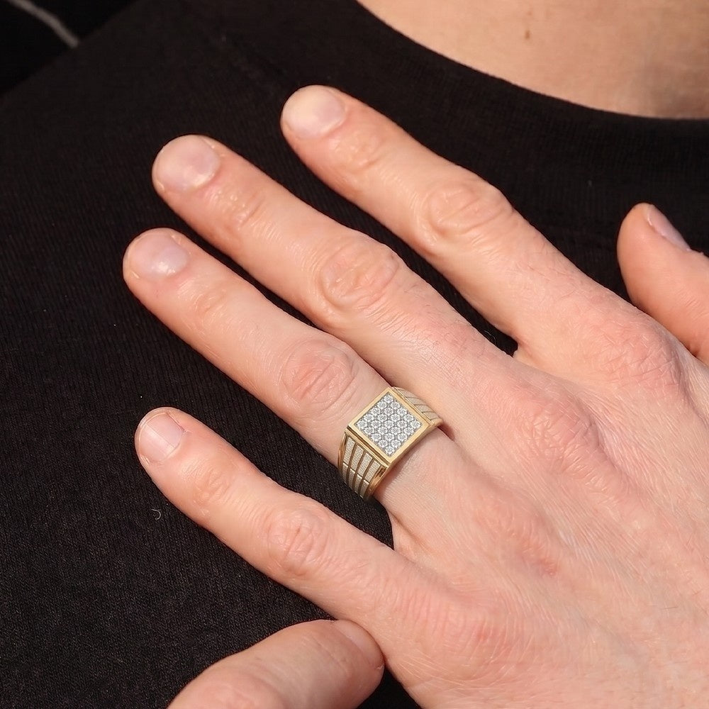Hand wearing a gold ring with diamonds on a black background