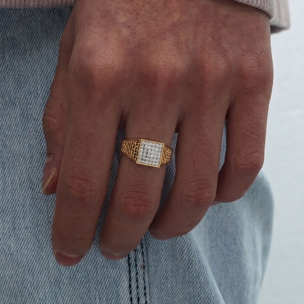 Gold ring with diamonds on a person's finger against a denim background