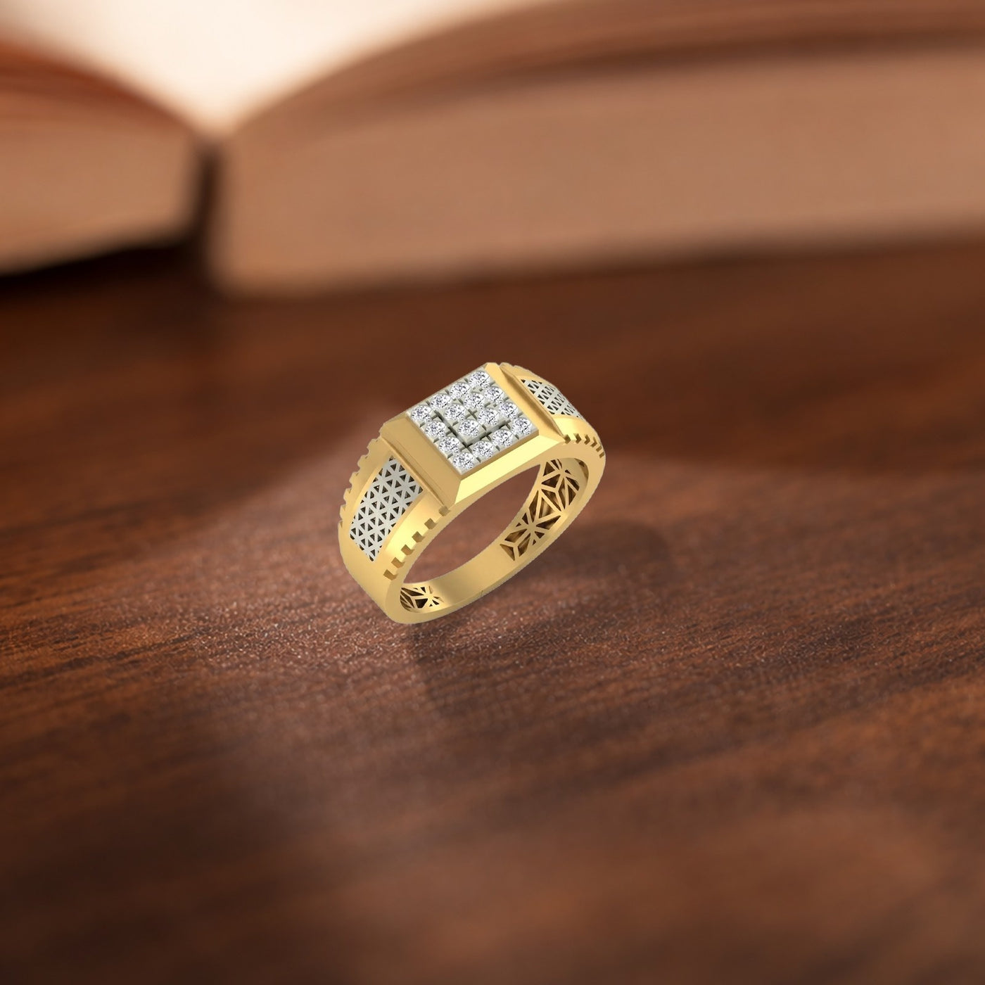 A gold ring with a square face, set with clear stones on the top and textured pavé detailing on the sides, resting on a dark wooden surface.