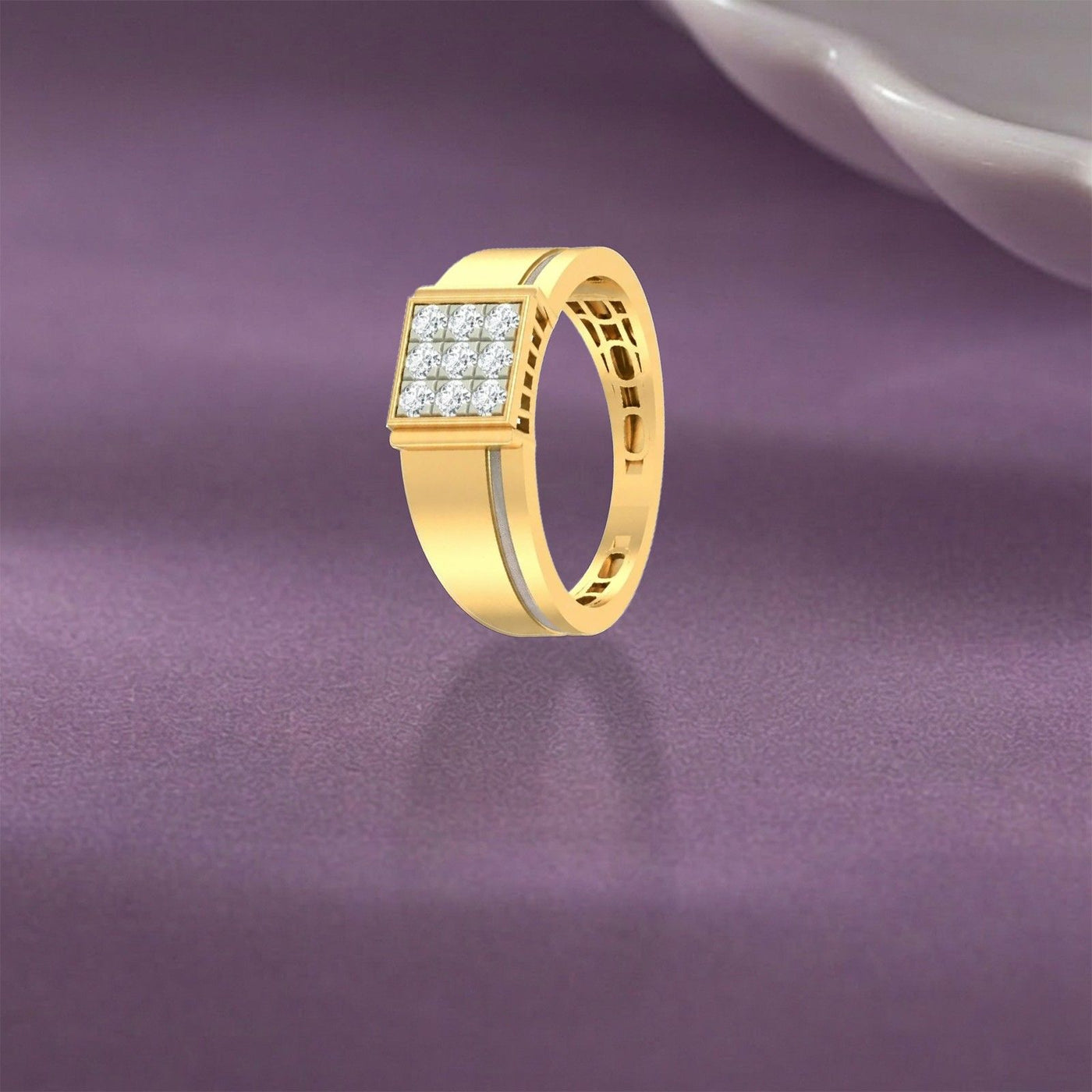 A gold ring with a square face paved with small clear stones, shown on a purple surface.