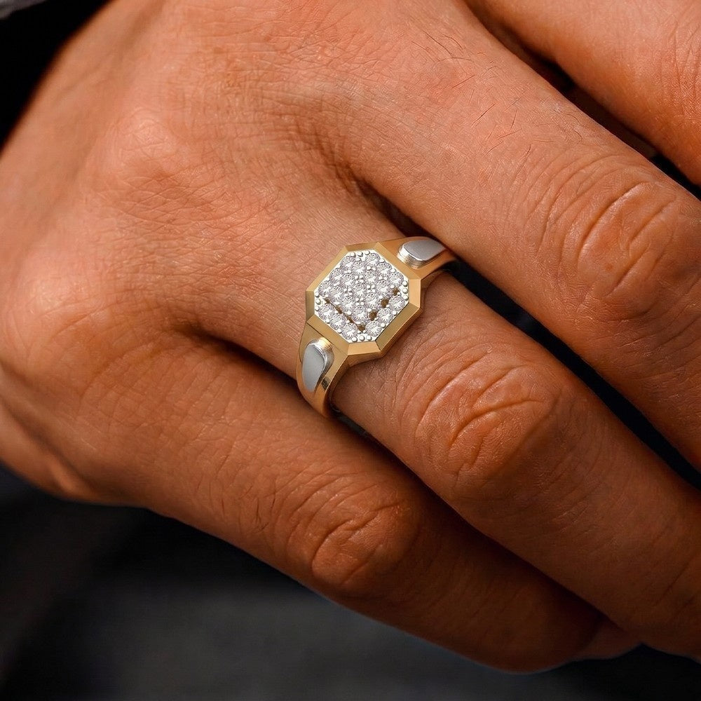 Close-up of a hand wearing a gold ring with a diamond design on a dark background
