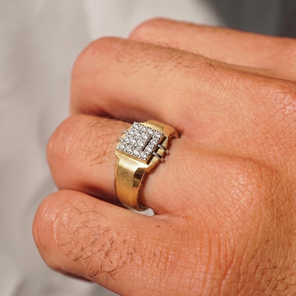 Gold ring with diamonds on a finger against a neutral background