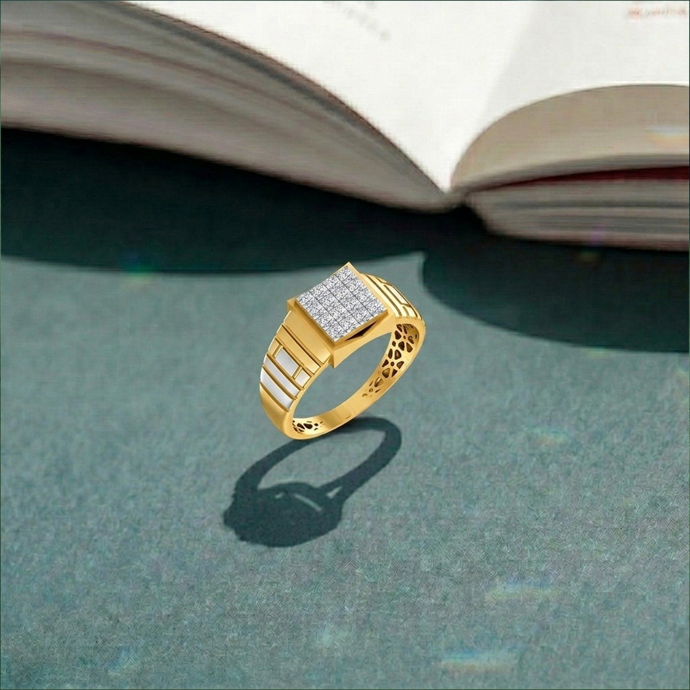 Gold ring with diamond accents on a textured surface with an open book in the background