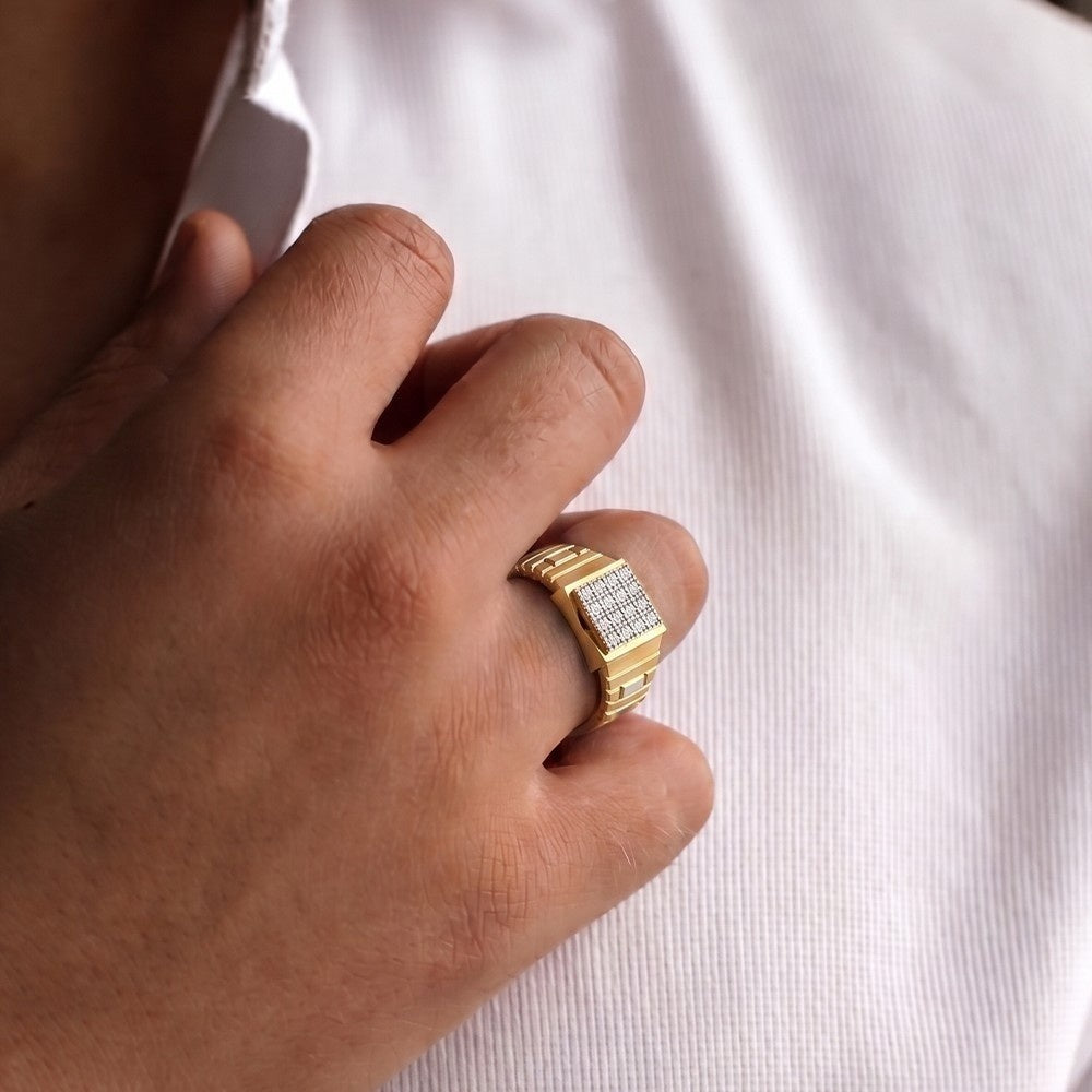 Gold ring with diamonds on a person's finger against a white background