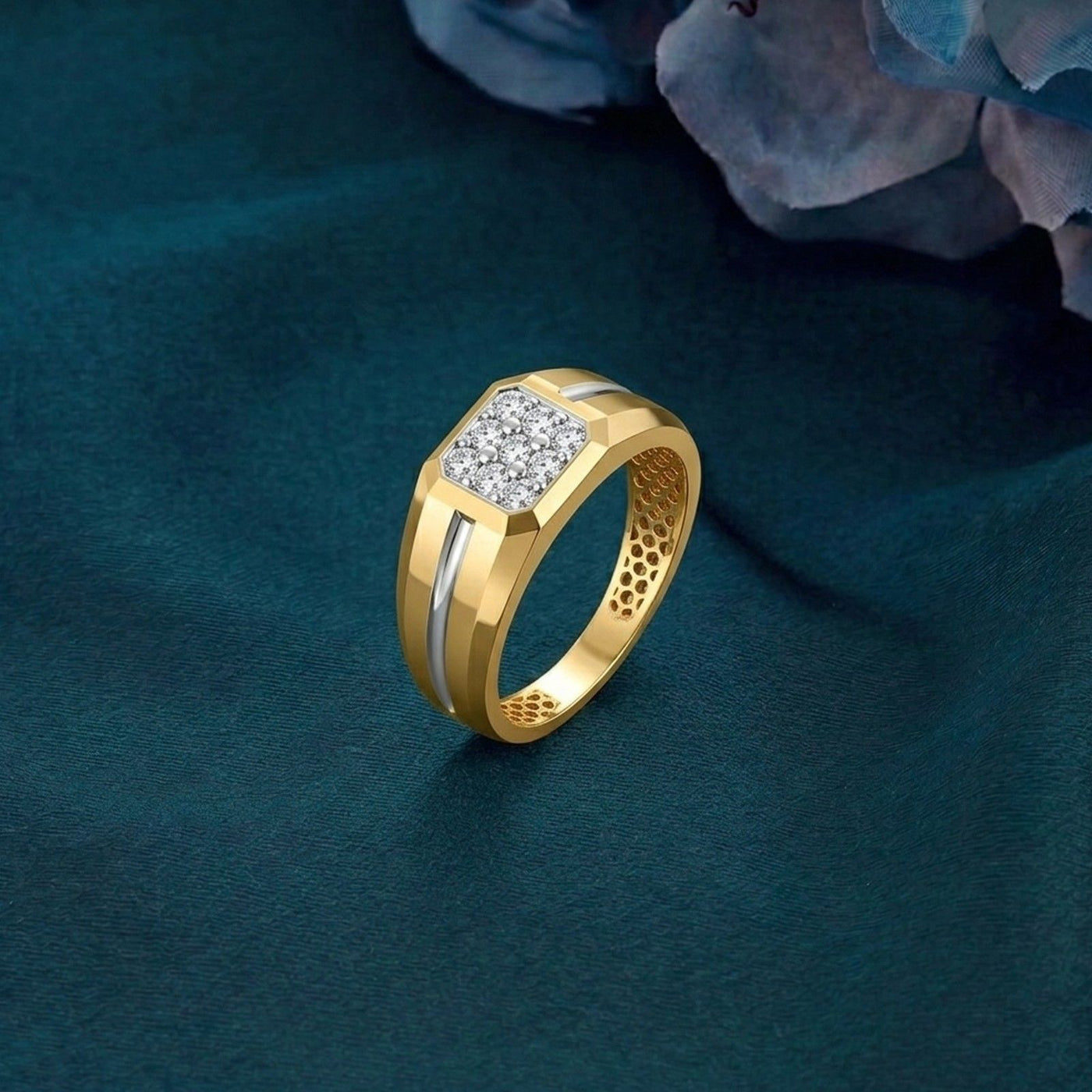 Gold and diamond band ring for men featuring a sparkling diamond accents on a teal surface.