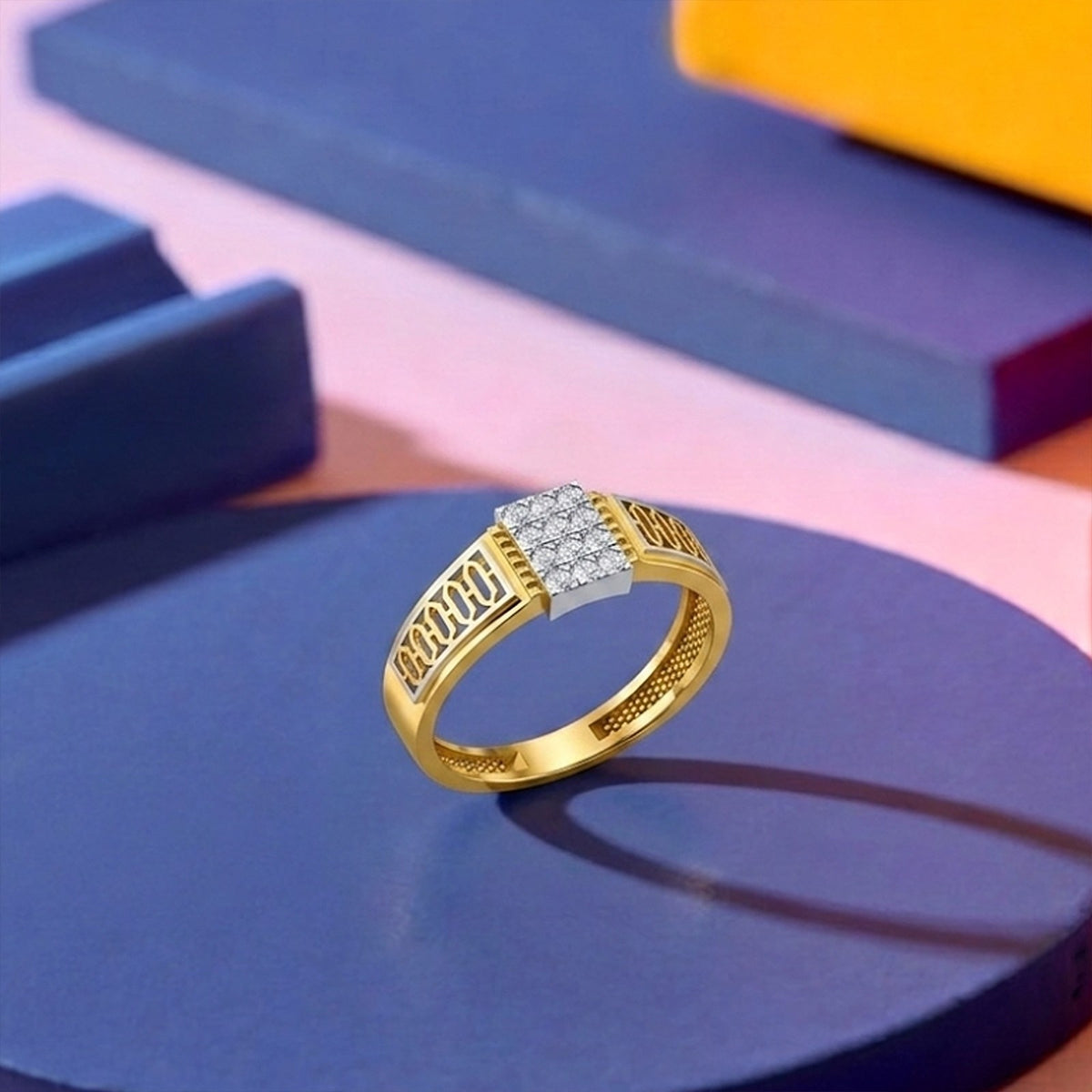 A gold ring with a square diamond cluster on the face and textured geometric band details, displayed on a dark blue circular platform.
