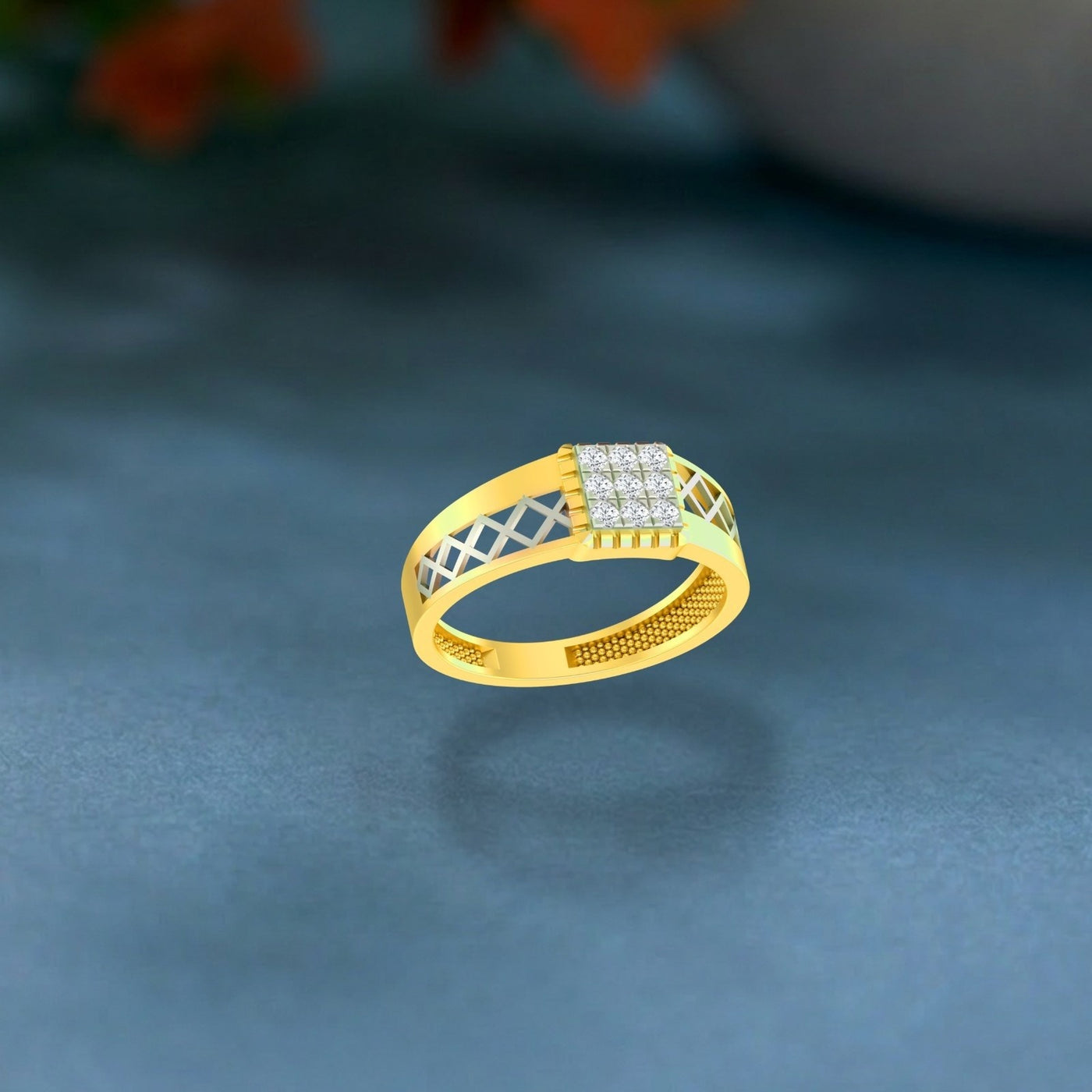 Gold and diamond men ring on a teal surface.