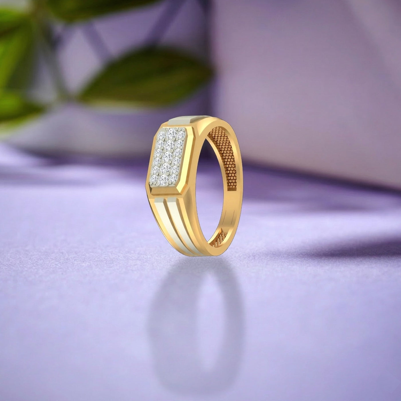 Gold ring with a rectangular diamond, shown on a blue surface.