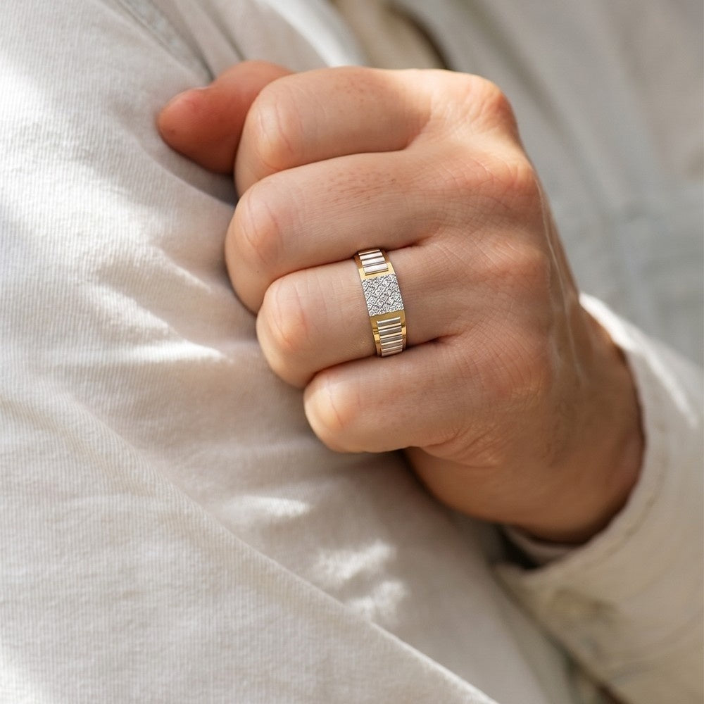 Hand wearing a gold ring with diamonds on a light fabric background.