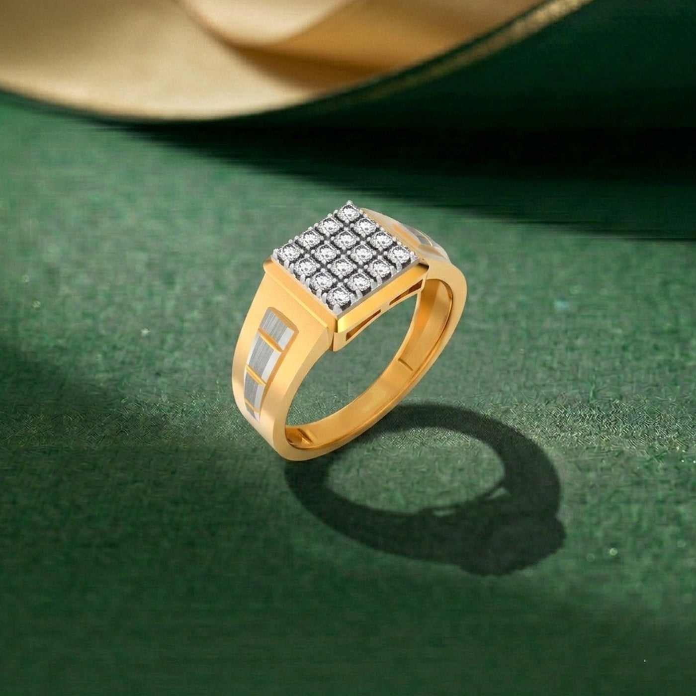 Gold and diamond mens ring on a green surface. 