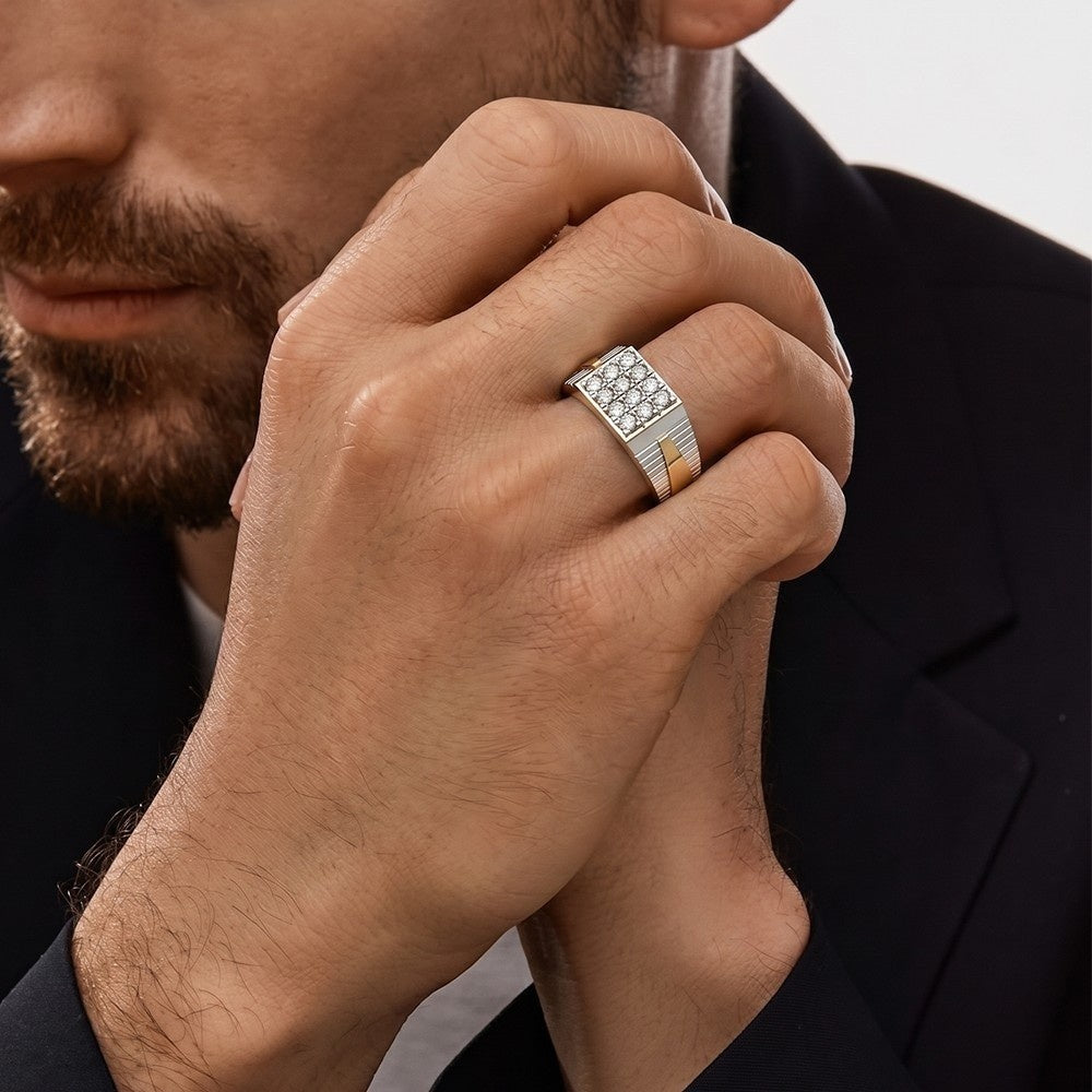 Close-up of a man's hand wearing a silver ring with a diamond, against a neutral background.