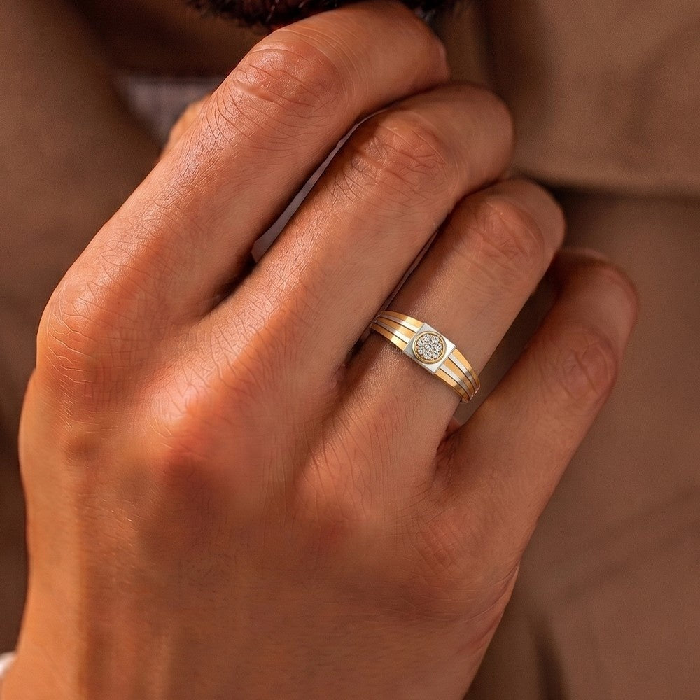 A close-up of a hand wearing a delicate gold and diamaond band ring.