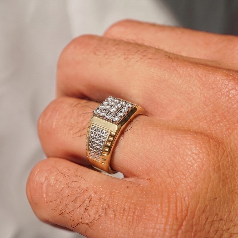 Gold ring with diamonds on a finger against a neutral background