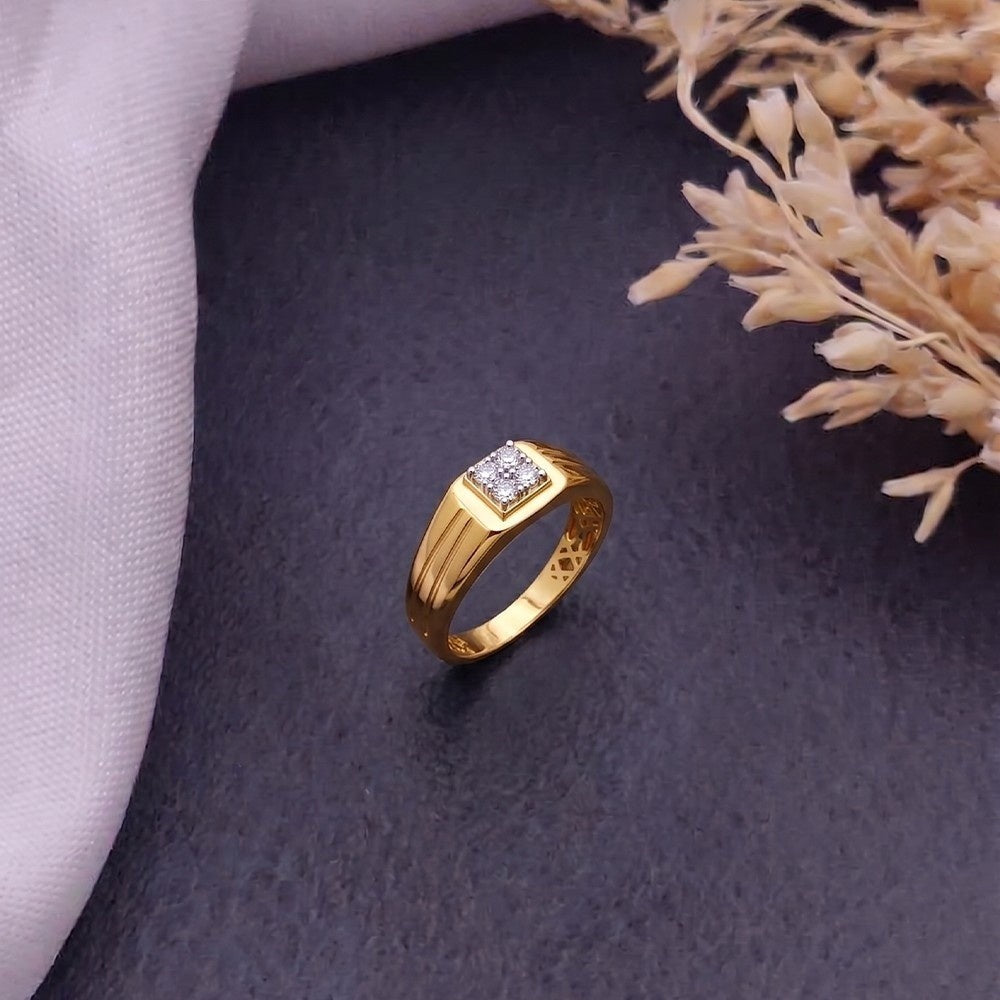 Gold and diamond men's ring on a grey surface.