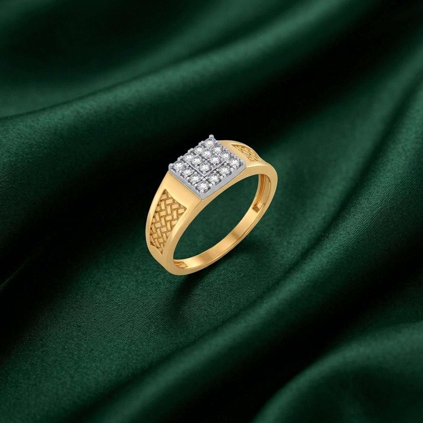 A gold ring with a square diamond cluster and textured band, displayed on a dark green satin fabric background.