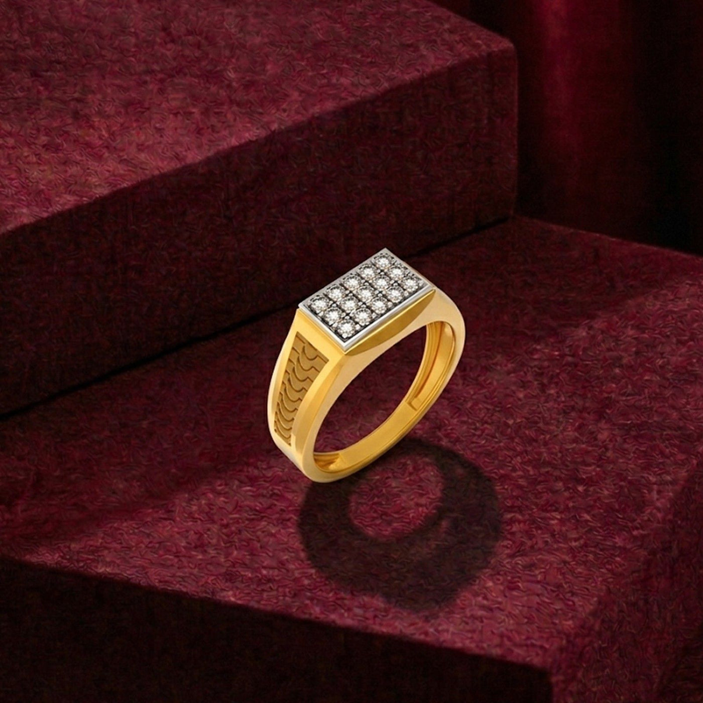 A gold signet ring with a square diamond-encrusted face, displayed on a textured dark red velvet surface.