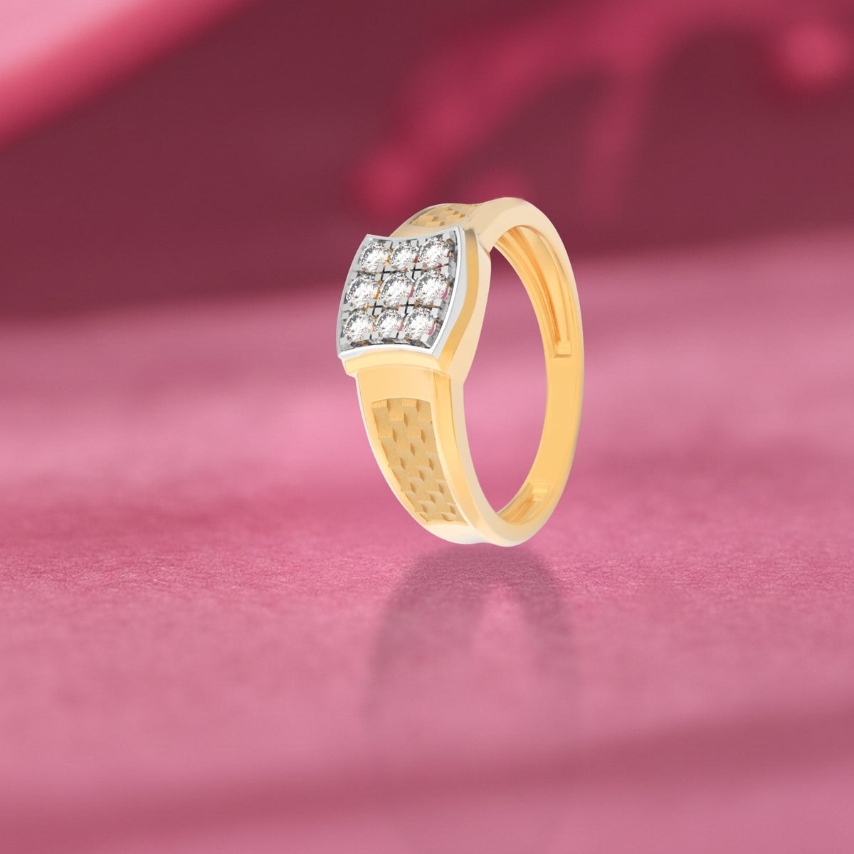 Gold ring with diamond accents on a pink fabric background