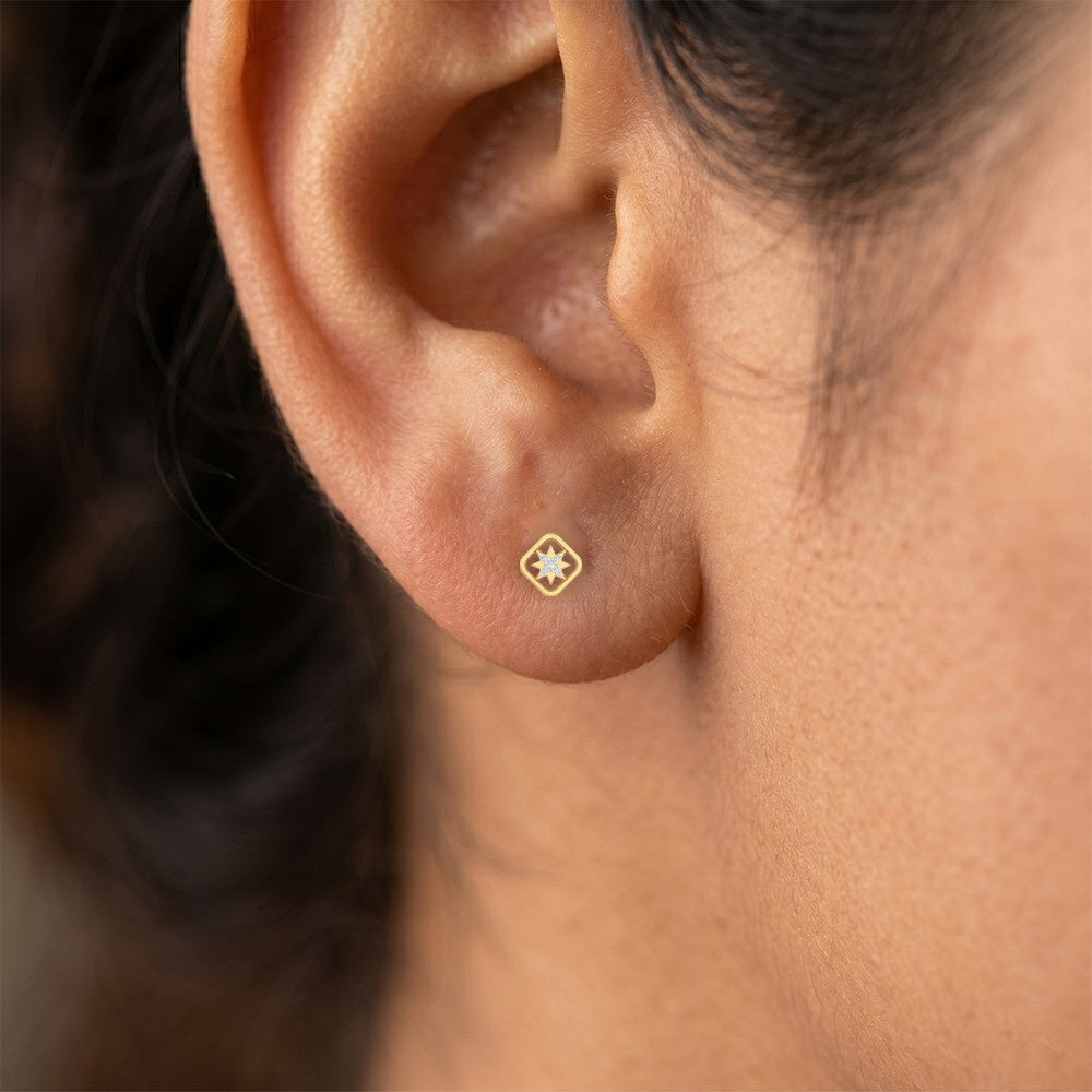 Close-up shot of a gold and diamond star design earring.