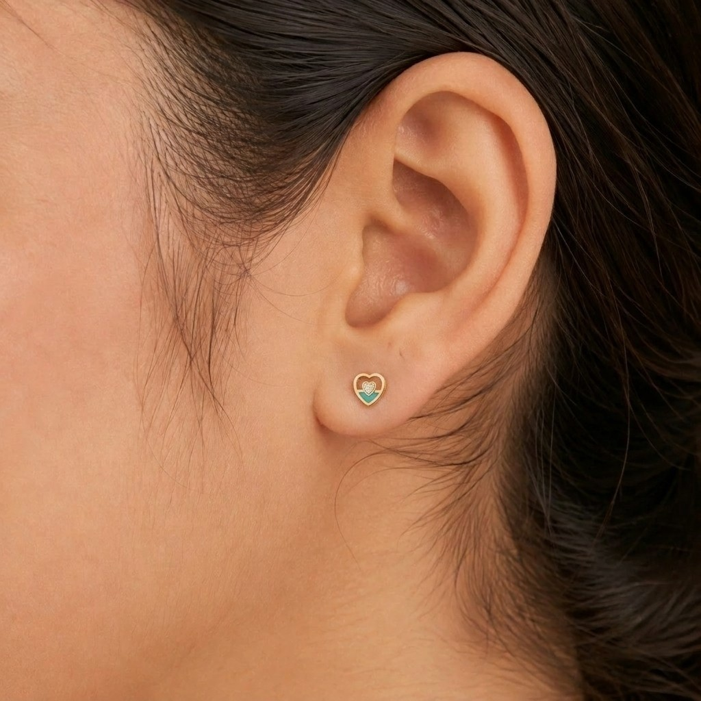 Close-up shot of a gold and diamond heart-shaped stud earrings.