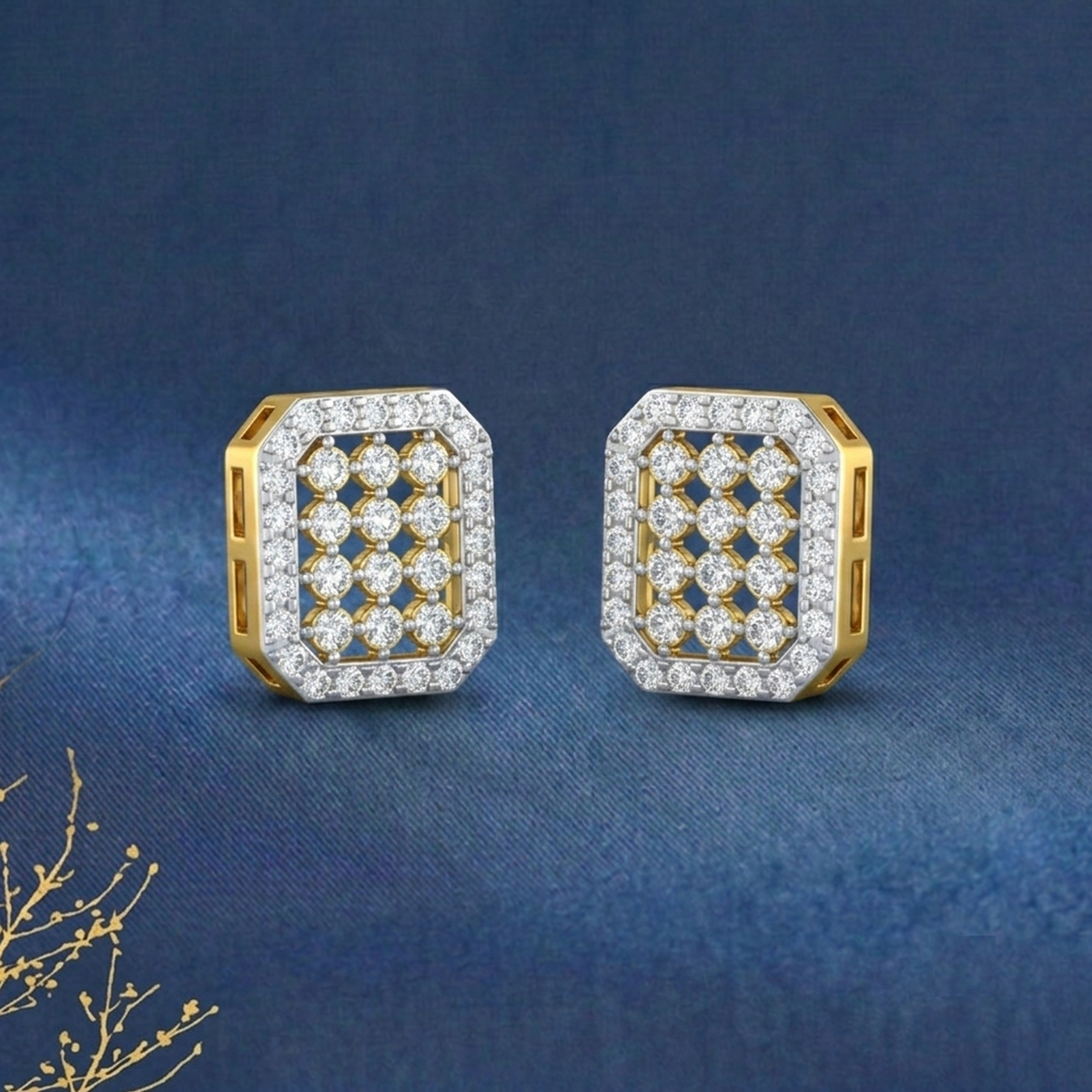 A pair of gold-toned rectangular stud earrings set, displayed on a textured dark blue background.