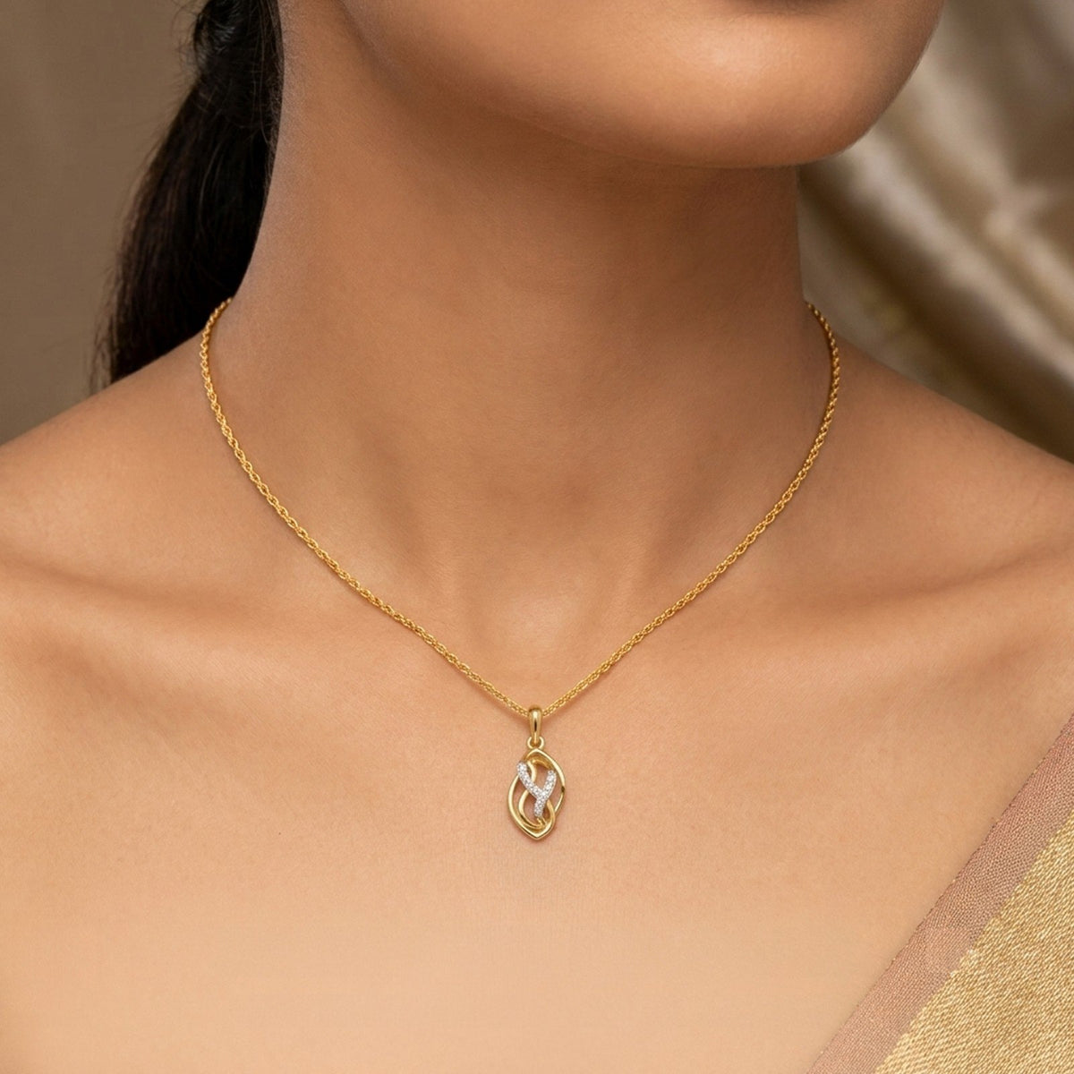 Gold and diamond pendant worn by a person.