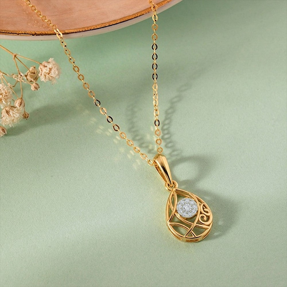 Gold and diamond teardrop-shaped pendant on a light green background