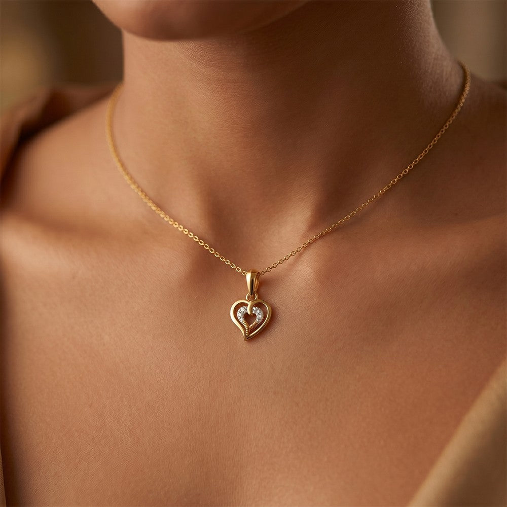 Gold and diamond heart-shaped pendant on a person.