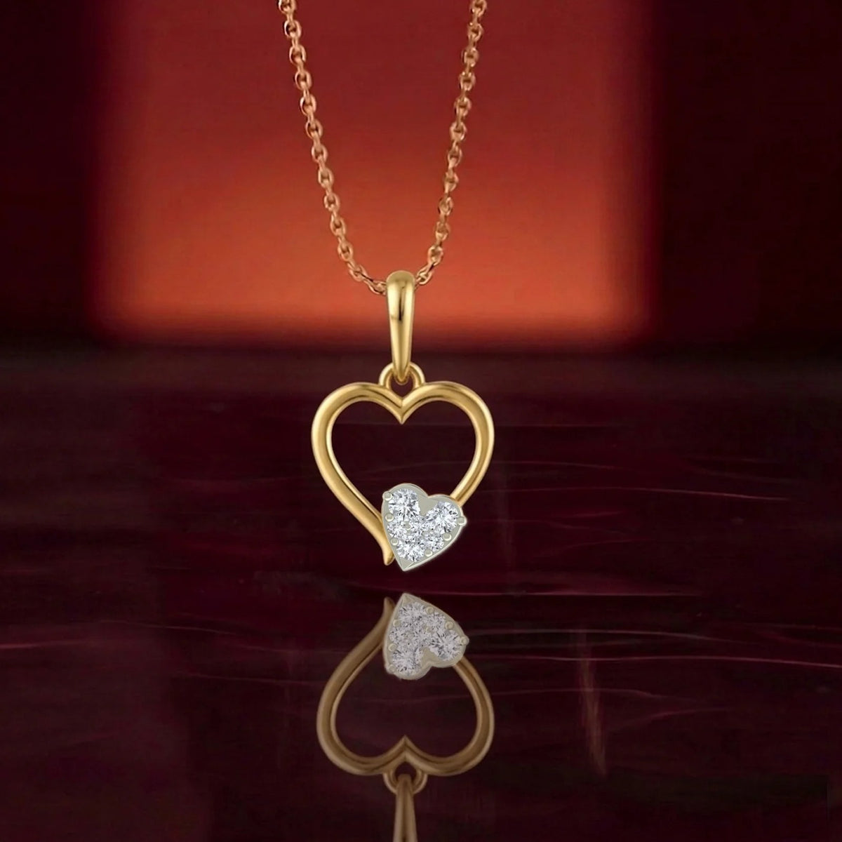 Gold heart-shaped diamond pendant on a reflective surface.