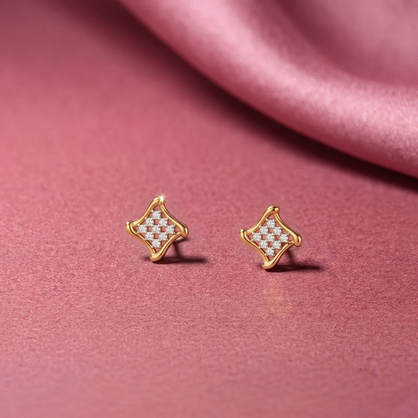 Gold and diamond square stud earrings on a pink background.