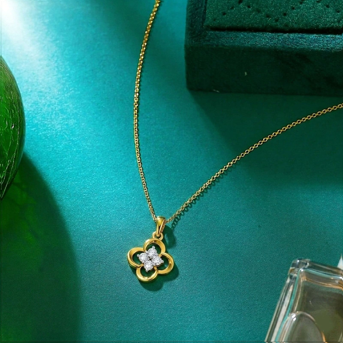 Gold and diamond floral-shaped pendant on a blue surface.