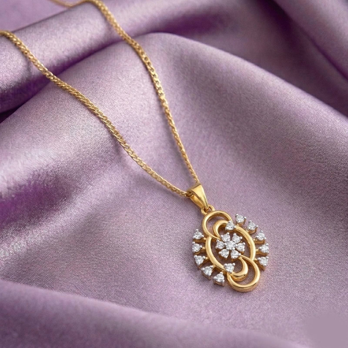 Gold pendant with diamond accents on a purple background.