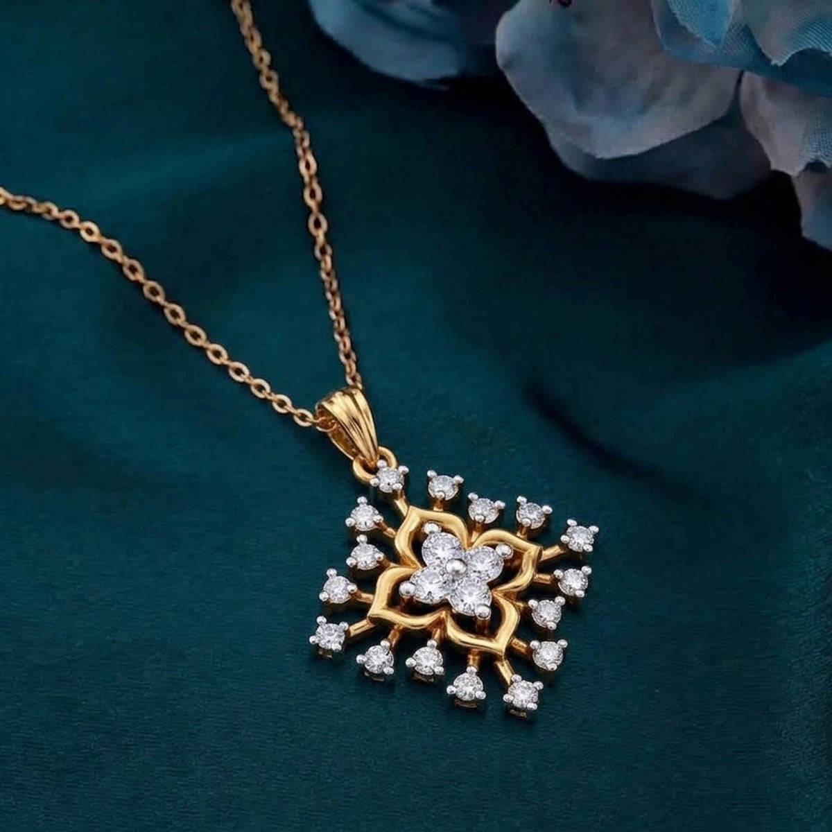 Gold with a diamond pendant on a teal surface.