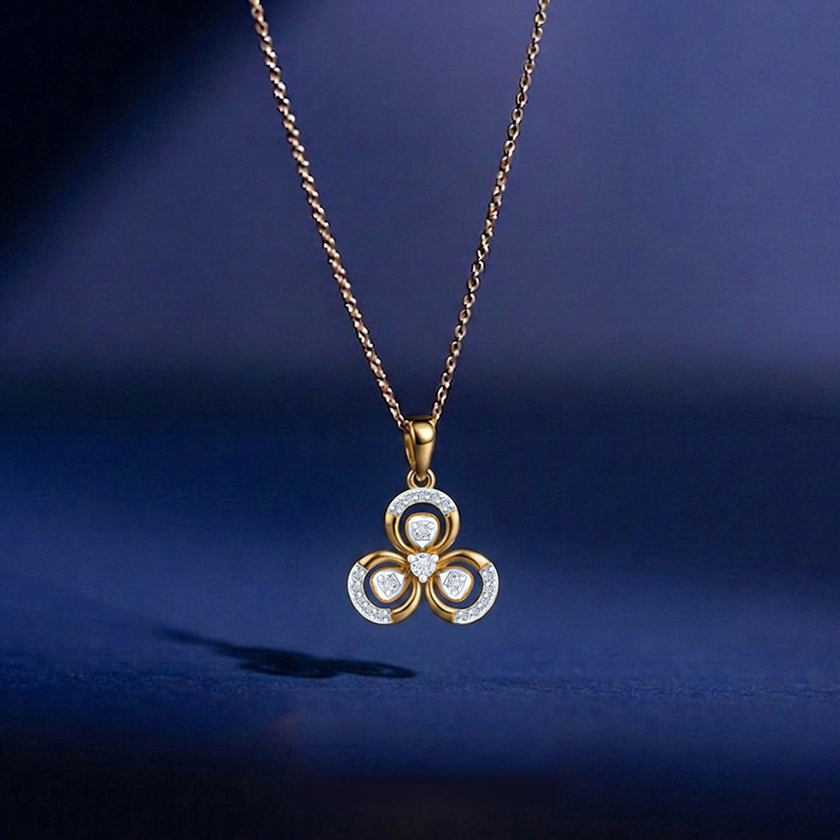 Gold necklace with a floral pendant on a dark blue background