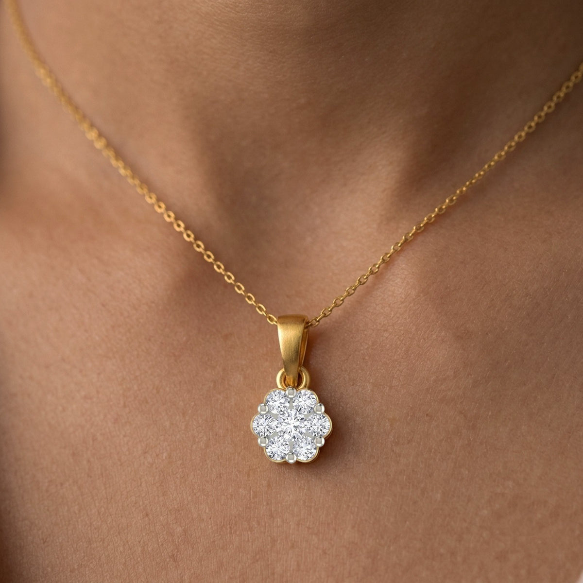 Gold with a diamond pendant on a person's neck