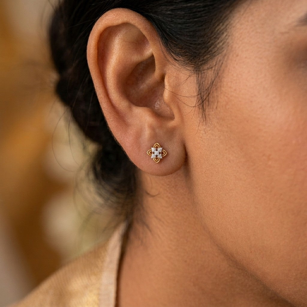 A close-up of a person's ear wearing a stud earring with a floral design.