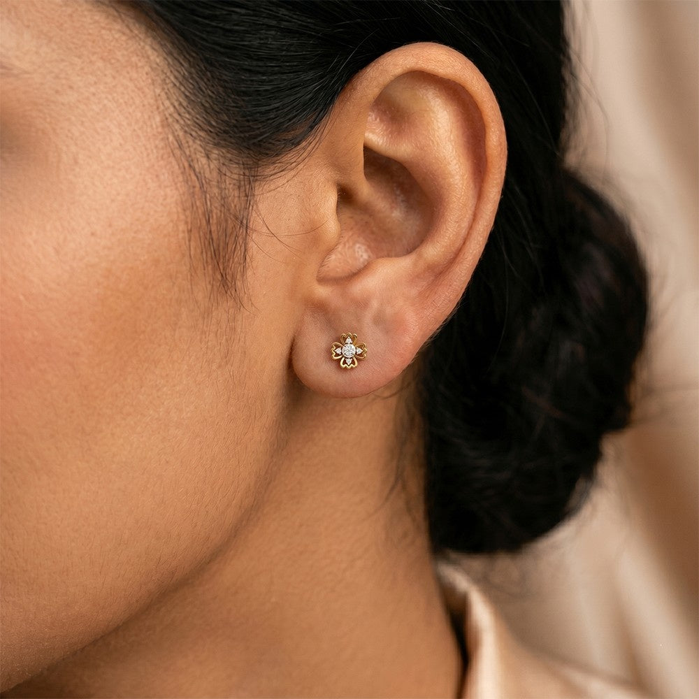 Close-up shot of a gold and diamond floral stud earrings.