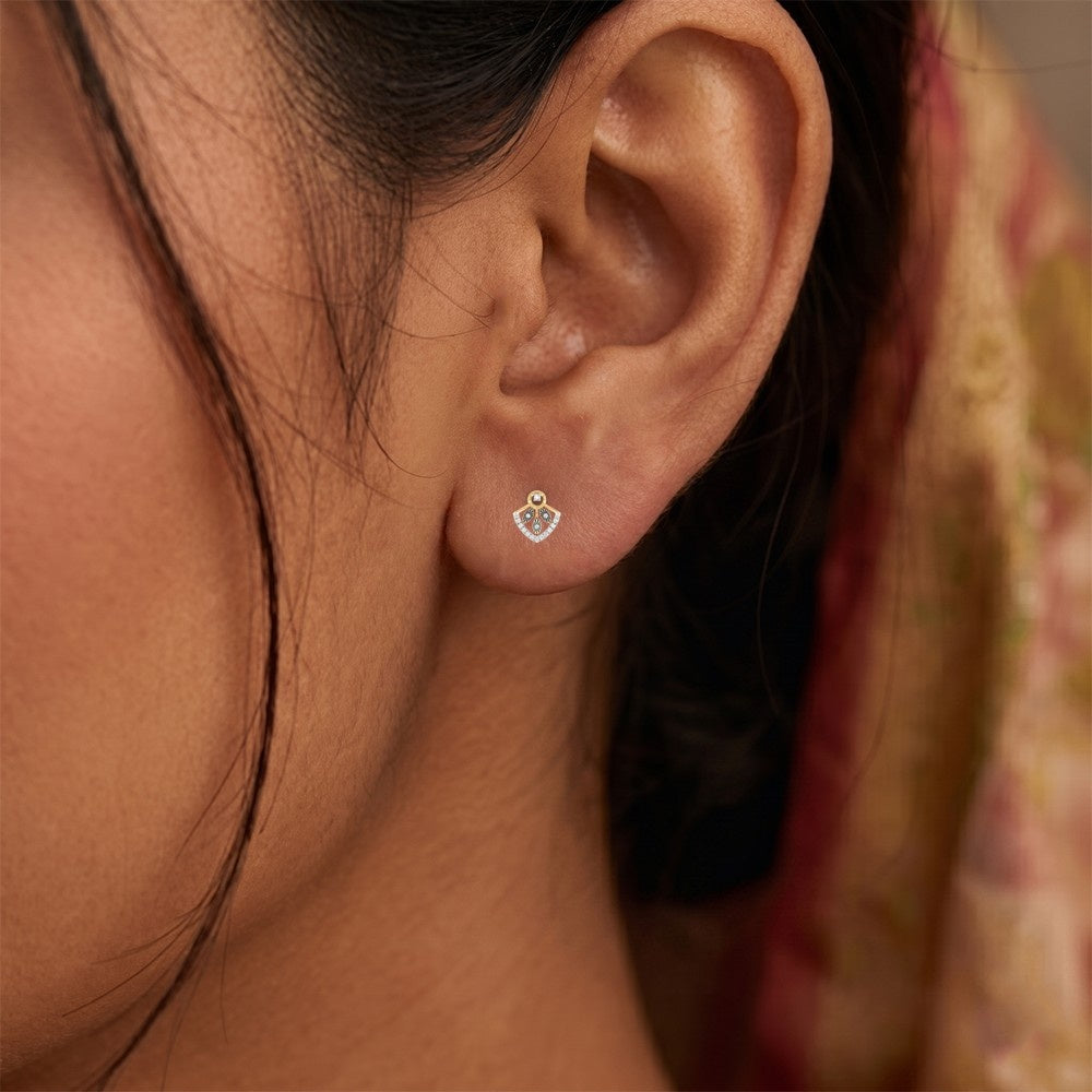 Close-up shot of a gold and diamond earrings with diamond accents.