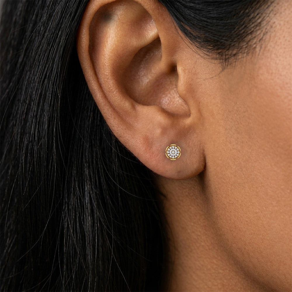 A close-up of a person's ear wearing a round stud earring.