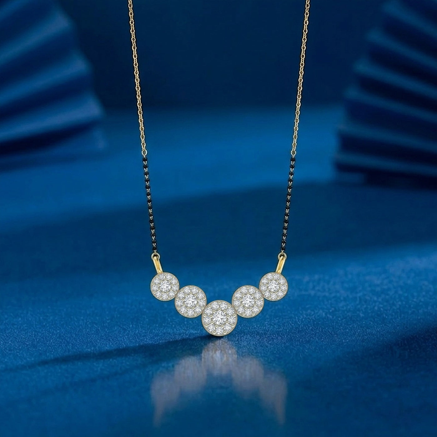 A gold mangalsutra with black beads featuring five round diamond-encrusted circles displayed against a dark blue background