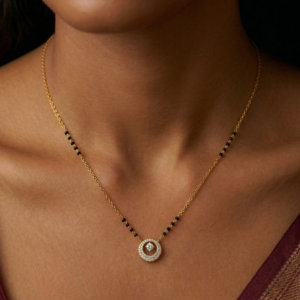 Gold and diamond mangalsurta with a circular diamond worn by a person