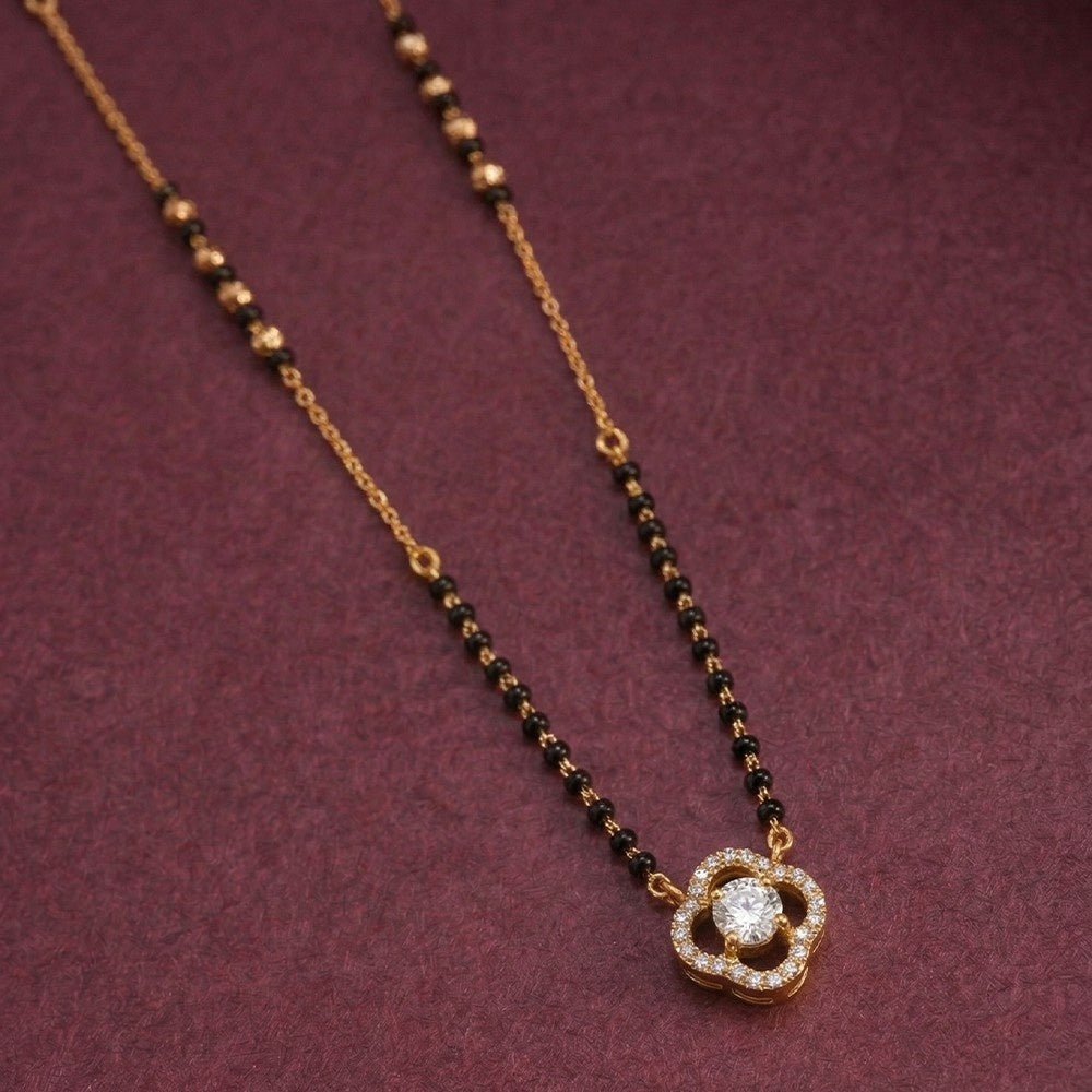 gold and diamond mangalsutra with a floral diamond on a purple background