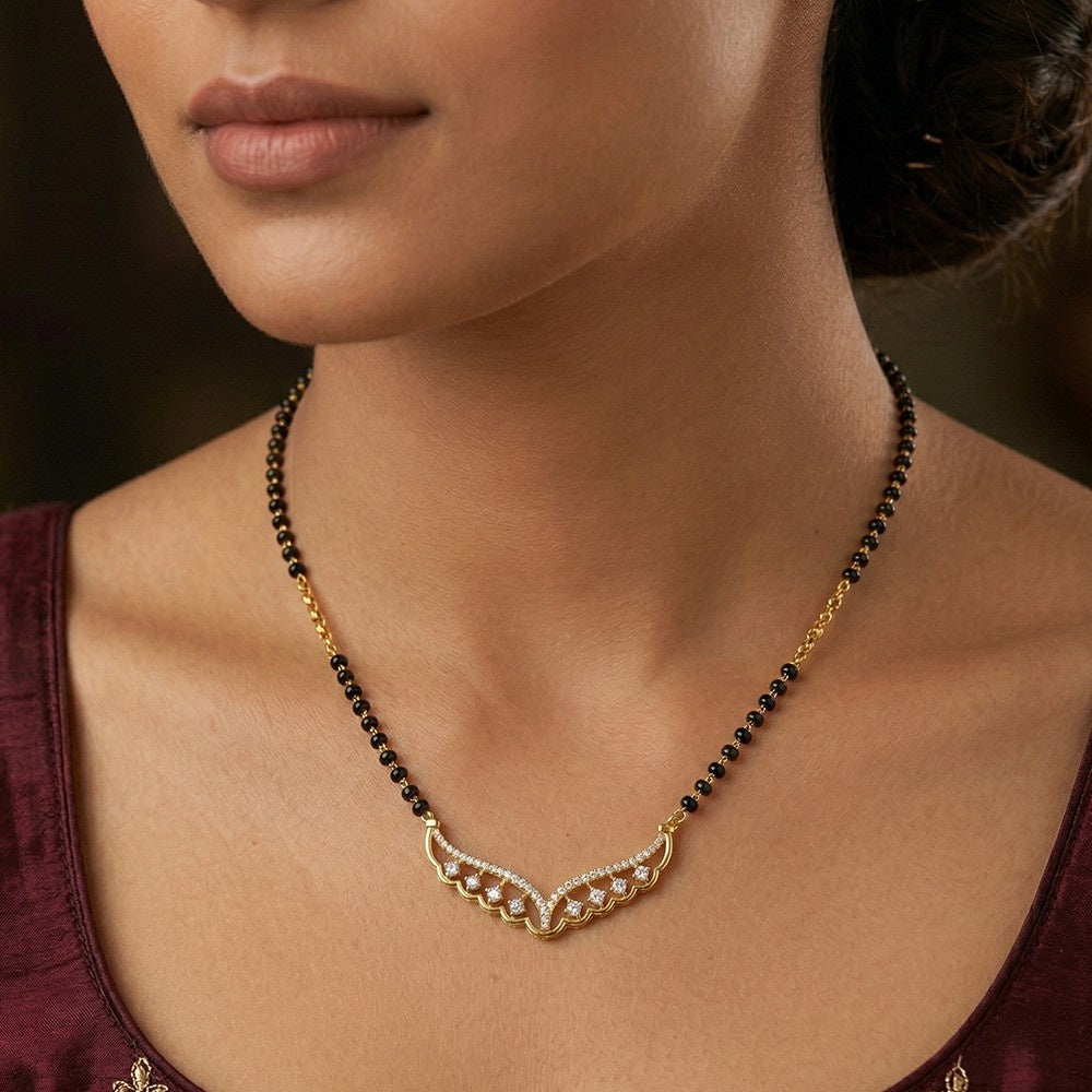 Close-up of a woman wearing a gold and black beaded mangalsutra.