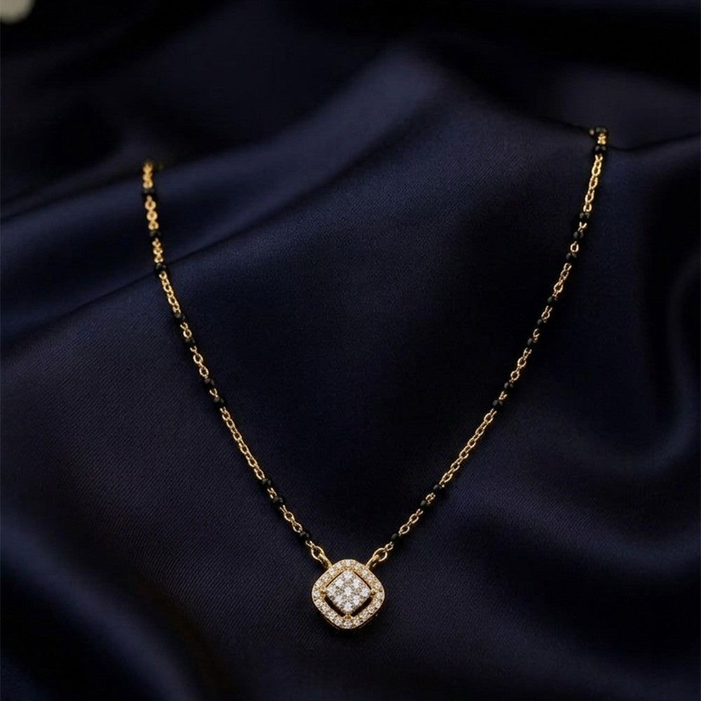 gold and diamond mangalsutra on a dark fabric background