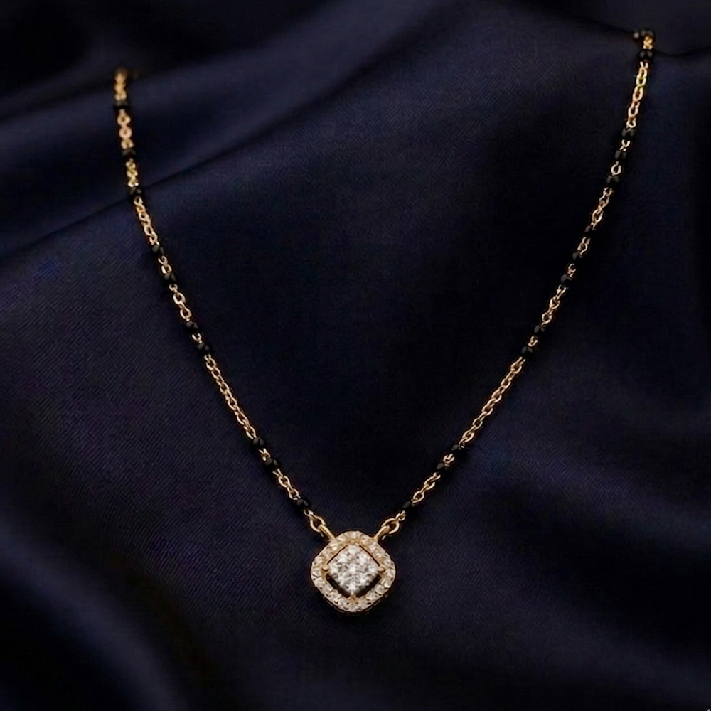 yellow Gold and diamond mangalsutra with a diamond on a dark blue fabric background