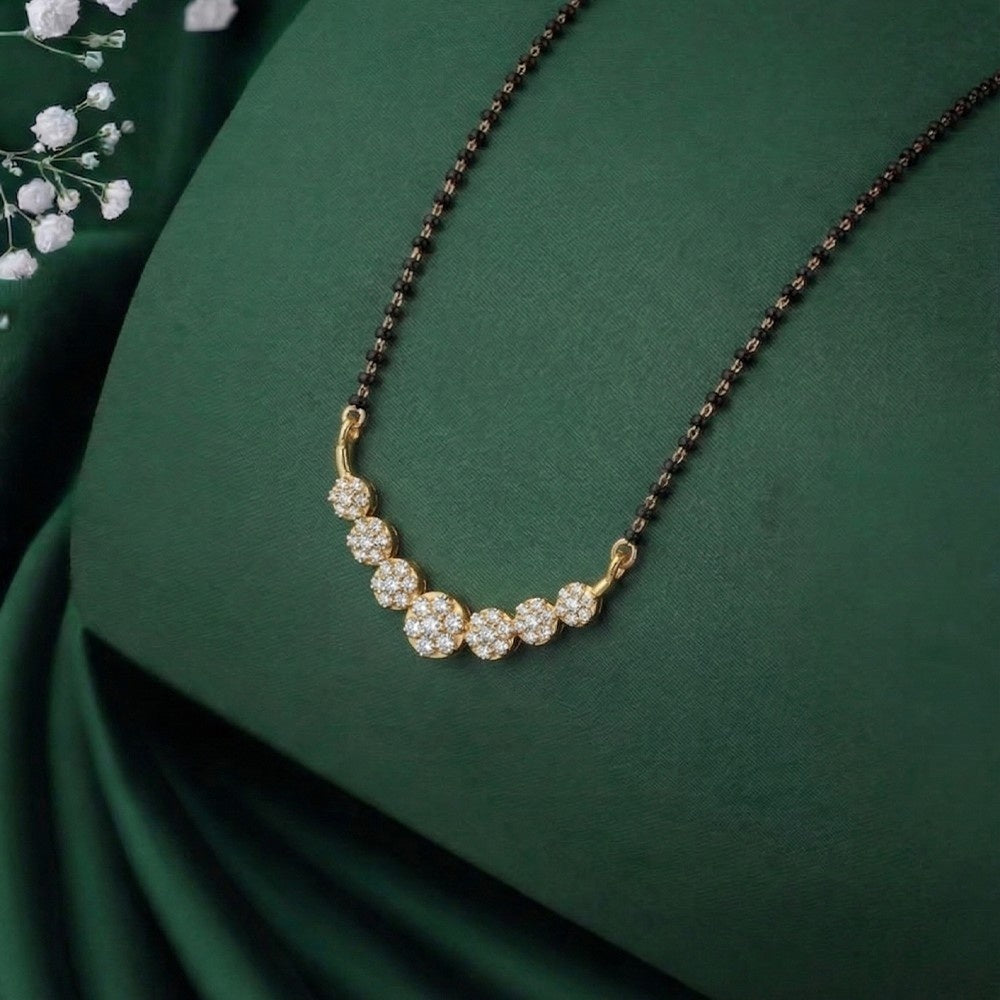 Gold mangalsutra with diamonds on a green fabric background