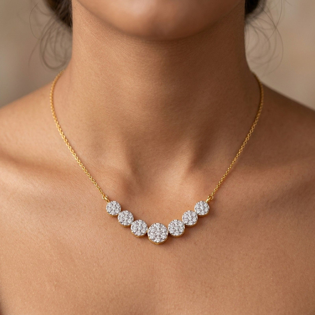 A close-up of a model wearing a delicate gold mangalsutra with five small round diamond clusters at the center, set against a soft beige background.