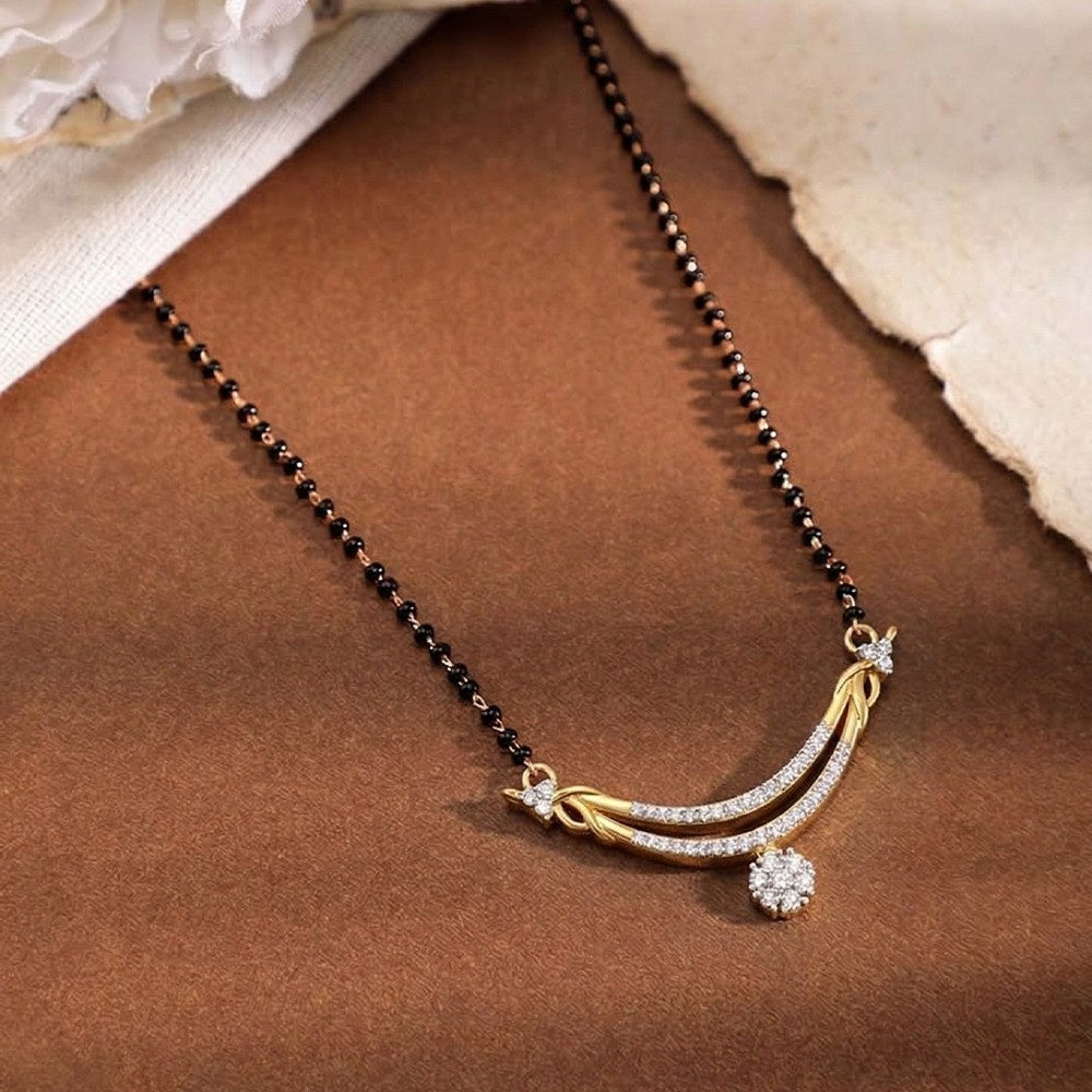yellow gold and diamond mangalsutra  on a brown surface
